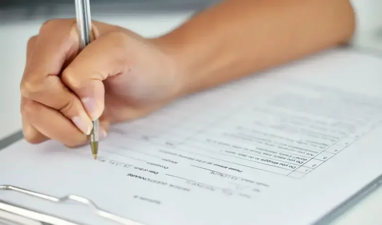 Someone answering questions on a clipboard during a work history background check.